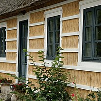 Reethaus mit weißem Holzgitter Reethaus mit weißem Holzgitter