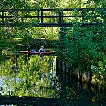 Paddler und Brücke über ein Fließ Paddler und Brücke über ein Fließ
