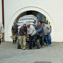 Baukolonne fährt Wagen mit Zement durchs Tor