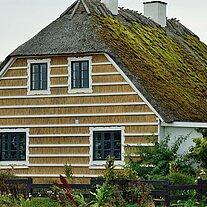 Reethaus mit weißem Holzgitter Reethaus mit weißem Holzgitter