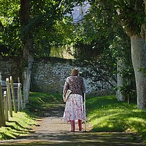 alte Frau am Friedhof