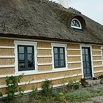 Reethaus mit weißem Holzgitter Reethaus mit weißem Holzgitter
