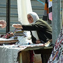 Marktfrau am Stand gibt Geld zurück Marktfrau am Stand gibt Geld zurück