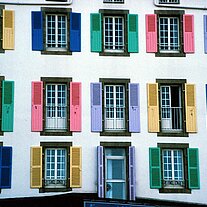 Haus mit verschiedenfarbigen Fensterläden